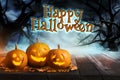 Happy Halloween. Scary Jack O`Lantern pumpkins surrounded by mystical fog in night Royalty Free Stock Photo