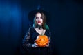 Happy Halloween sexy witch holding carved pumpkin on black background Royalty Free Stock Photo