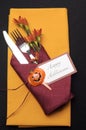 Happy Halloween table place setting with red and orange napkins - vertical aerial.