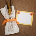 Happy Halloween Table Place Setting with Silverware, napkin, wheat and a yellow and white name card with cute pumpkin decorations