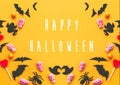 Happy Halloween text, greeting card.  Halloween candy frame with skulls, black bats, ghost, spider paper decorations on yellow Royalty Free Stock Photo