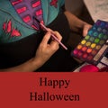 Happy halloween text on red with caucasian woman body painting costume