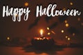 Happy Halloween text sign on pumpkin candle burning on dark orange background with lights and flying black bats. Season`s greetin Royalty Free Stock Photo