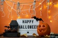 Happy Halloween white sign with black letters, pumpkin and halloween decoration. Royalty Free Stock Photo