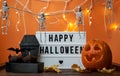 Happy Halloween white sign with black letters, pumpkin and halloween decoration. Royalty Free Stock Photo