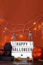 Happy Halloween white sign with black letters, pumpkin and halloween decoration. Royalty Free Stock Photo