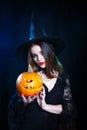 Happy Halloween . Halloween witch with a magic pumpkin on black background. Royalty Free Stock Photo