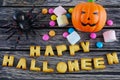 Happy Halloween words decoration with scary spider, candy and pumpkin on wooden background Royalty Free Stock Photo