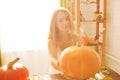 Happy Halloween. Young woman preparing for Halloween in the kitchen. Beautiful woman with pumpkins.