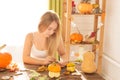 Happy Halloween. Young woman preparing for Halloween in the kitchen. Beautiful woman with pumpkins.