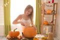 Happy Halloween! Young woman preparing for Halloween in the kitchen. Beautiful woman with pumpkins