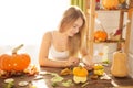 Happy Halloween! Young woman preparing for Halloween in the kitchen. Beautiful woman with pumpkins