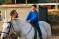 Happy handicapped boy riding a horse during equine therapy Royalty Free Stock Photo