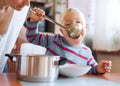 A handicapped down syndrome boy eating soup from a ladle indoors, lunch time. Royalty Free Stock Photo