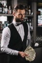 happy handsome bartender holding tips