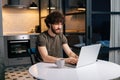 Happy handsome bearded young businessman working on project at laptop typing, using online app sitting at table with Royalty Free Stock Photo