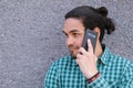 Happy and handsome black-haired man uses smartphone Royalty Free Stock Photo