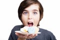 Happy handsome boy eating the macaron on white background. Royalty Free Stock Photo