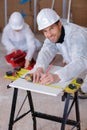 Happy handsome builder using measure tape Royalty Free Stock Photo