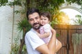 Happy handsome father holding adorable little baby daughter at house with happiness and smile face. Single dad embrace his infant Royalty Free Stock Photo