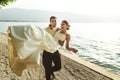 Happy handsome groom holding bride in his arms on beach at sunset Royalty Free Stock Photo
