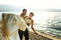 Happy handsome groom holding bride in his arms on beach at sunset Royalty Free Stock Photo