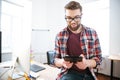 Happy handsome man with beard sitting and using tablet Royalty Free Stock Photo