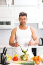 Happy handsome man cooking in kitchen at home. Royalty Free Stock Photo