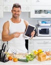 Happy handsome man cooking in kitchen at home. Royalty Free Stock Photo