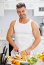 Happy handsome man cooking in kitchen at home. Royalty Free Stock Photo