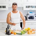 Happy handsome man cooking in kitchen at home. Royalty Free Stock Photo