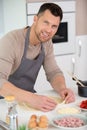 happy handsome man cooking in kitchen at home Royalty Free Stock Photo