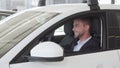 Happy handsome man examining interior of a new car sitting inside