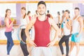 Happy handsome man with group peolpe in fitness class