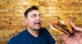 Happy handsome man with his fast food burger. Not so much healthy lifestyle, but whatever Royalty Free Stock Photo