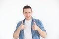 Happy handsome man showing thumbs up. A stylish man in a shirt has a smiling look, advertises a product. People, advertising, emot