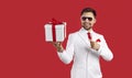 Happy handsome man in suit and glasses smiling and pointing at gift box in his hand Royalty Free Stock Photo