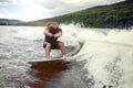 Happy handsome man wakesurfing in a lake