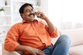 Happy middle aged indian man talking on phone at home Royalty Free Stock Photo