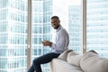 Happy handsome millennial African American man using mobile phone