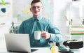 Happy handsome student in spectacles having an exelent mark for exam. Portrait of happy male student works on laptop Royalty Free Stock Photo