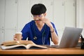 A happy Asian male medical student focuses on his medical research, reading a book Royalty Free Stock Photo