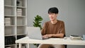 A happy and handsome young Asian man using his laptop in his home office Royalty Free Stock Photo