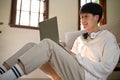 Happy Asian man using laptop while relaxing in his living room. people an technology Royalty Free Stock Photo