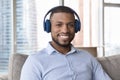 Happy handsome young Black business man in wireless head phones