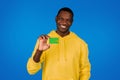 Happy handsome young black guy shows credit card, recommends finance savings Royalty Free Stock Photo