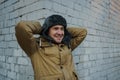 Happy handsome young man in cap with earflaps. The young man in the fur hat Royalty Free Stock Photo