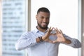 Happy handsome young man making hand heart at chest Royalty Free Stock Photo