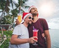 Happy handsome young men, gay family, celebrates New Year and Christmas at a tropical resort, LGBT values, equal rights for