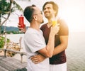 Happy handsome young men, gay family in a tropical resort with fruit necks, LGBT values, equal rights for everyone. Vacations and